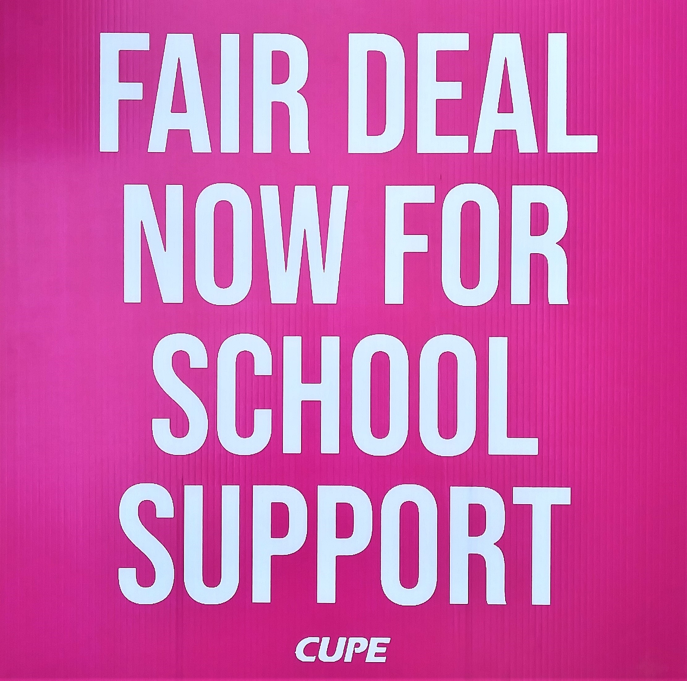 Fair deal now for school support message on a bright pink sign.